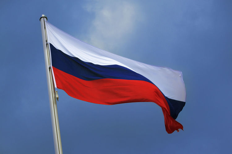 Low angle view of russian flag against blue sky