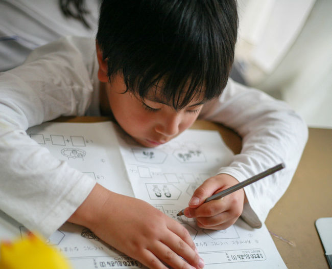 close-up of boy drawing on paper at home