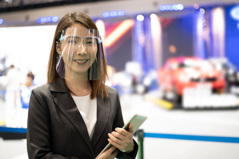 Portrait of asian car dealer wearing face shield working while pandemic