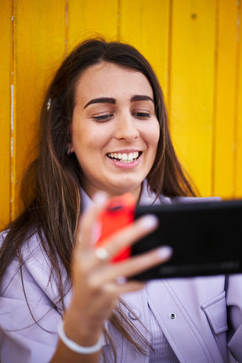 Portrait of a smiling young woman using smart phone