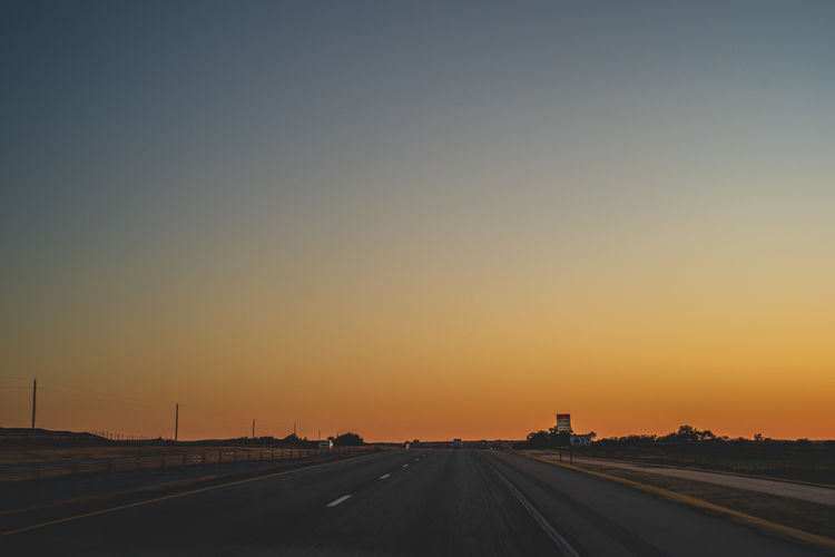 Road against clear sky during sunset