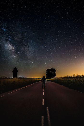 A man looking at the milky way in a dark way