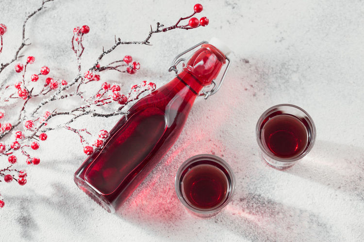 Two glasses of red cocktail, vodka or liqueur on light background