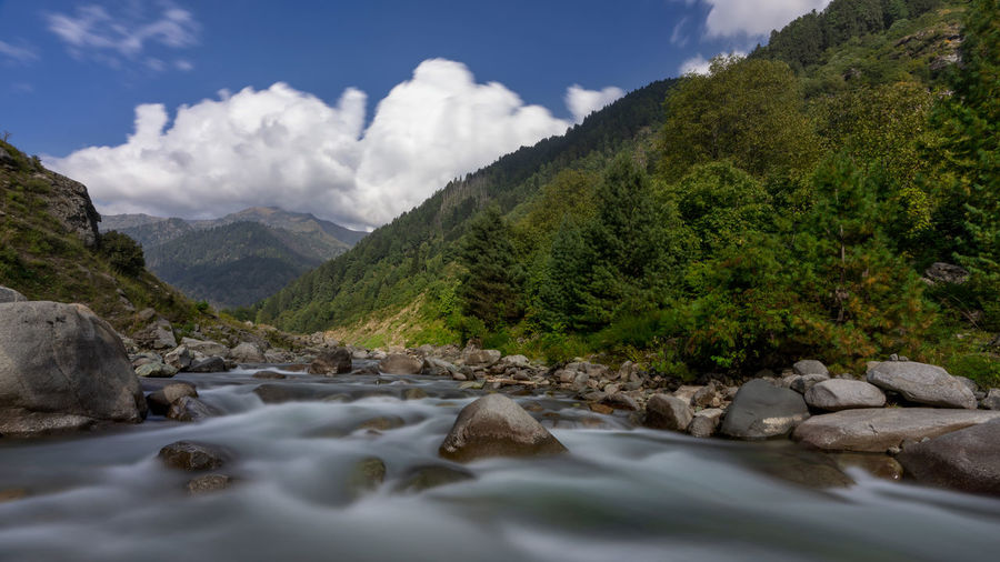Scenic view of river amidst rocks against sky