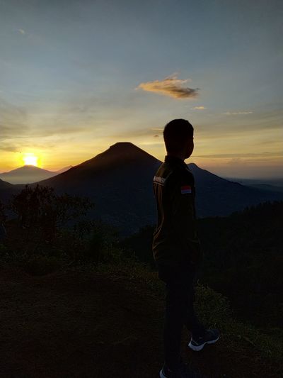 Full length of man standing on mountain during sunset