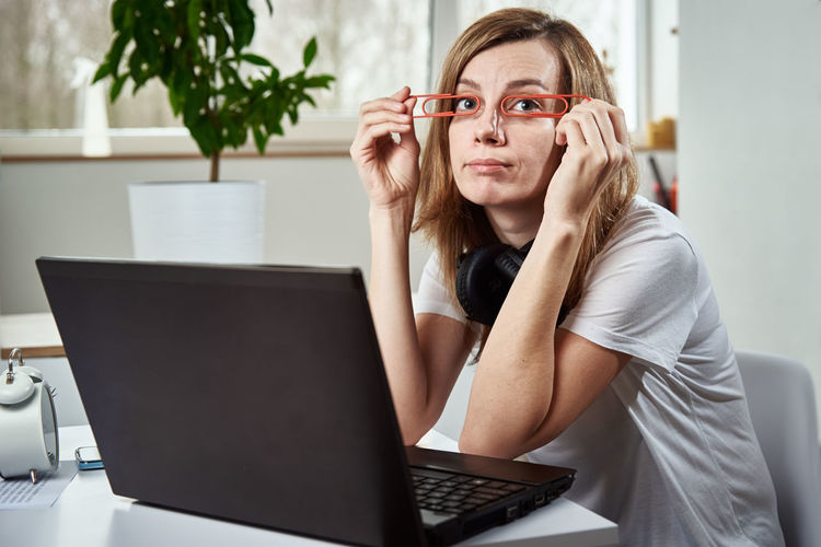 Freelancer woman sitting at workplace and procrastinating