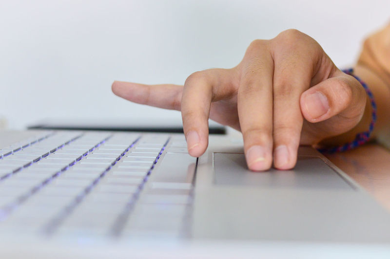 Cropped hands using laptop on table