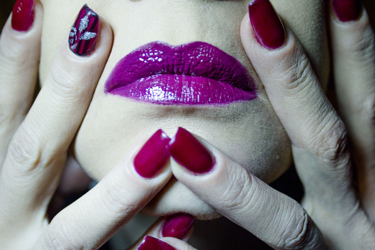 Close-up of woman with pink nail polish and lipstick