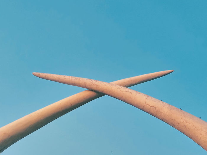 Low angle view of hand against blue sky
