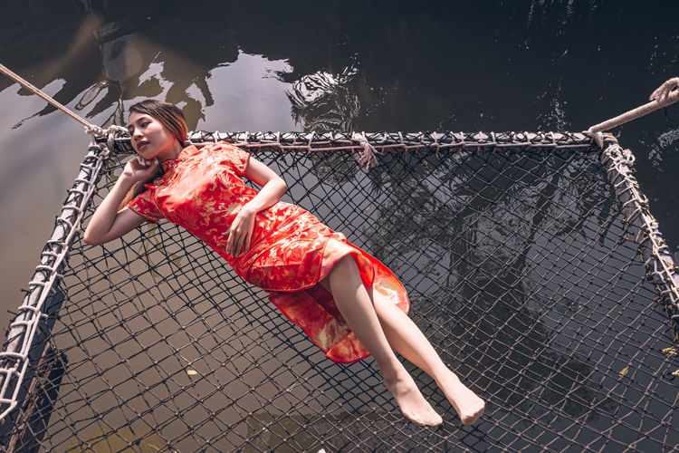 High angle view of woman on netting at lake