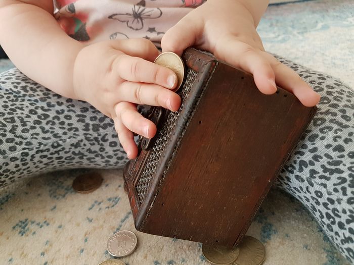 Low section of child playing with book on table