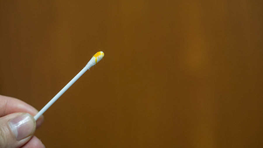 Close-up of hand holding cotton swab