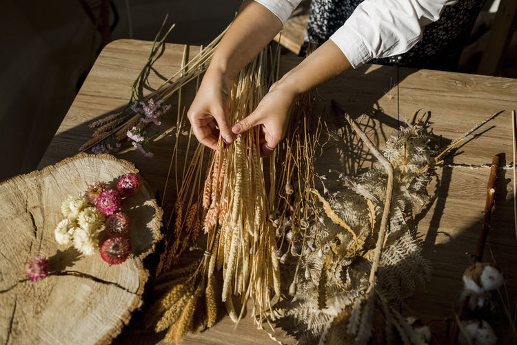 Young woman arranging dried flowers at home