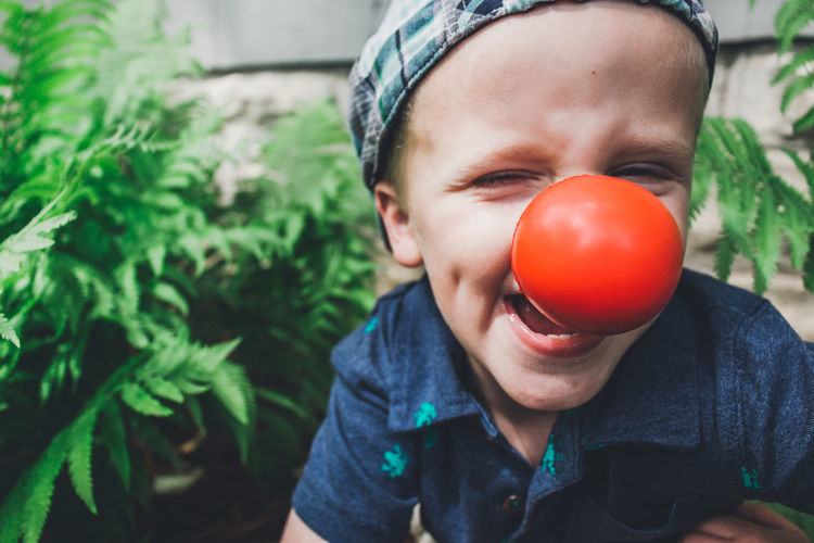 Close-up portrait of playful boy wearing clown nose