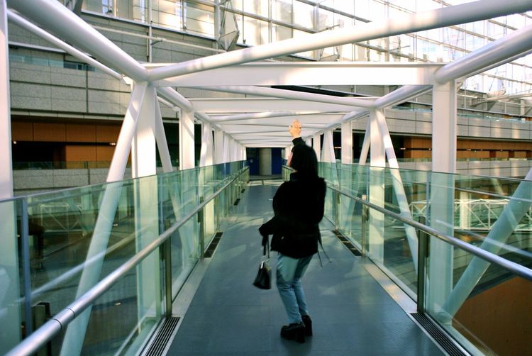 Full length rear view of woman touching rode while standing on footbridge