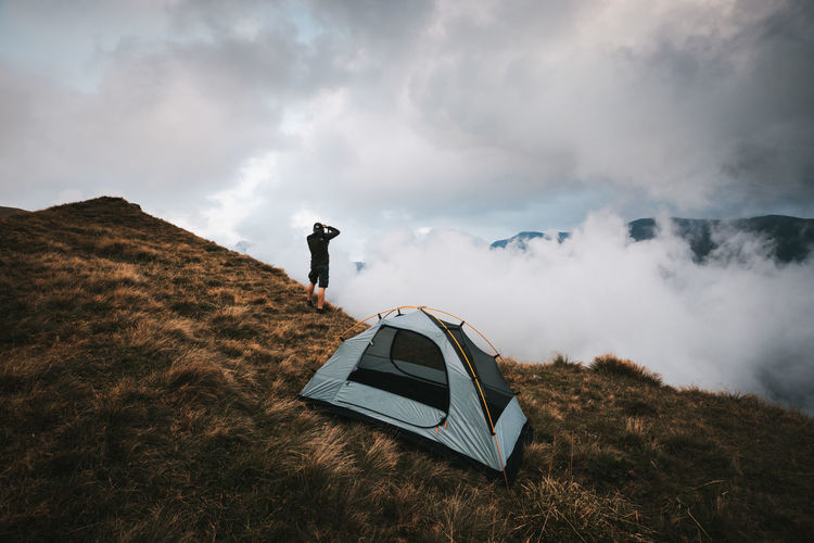Photographer standing near the tent in the high mountains.fagaras mountains,romania