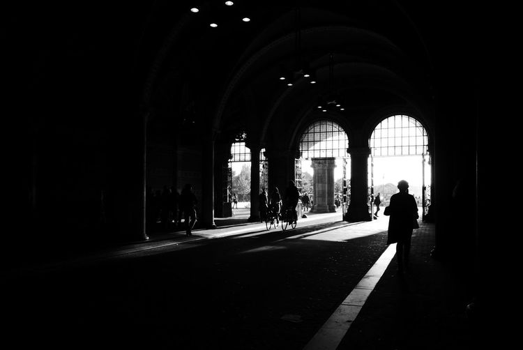 Silhouette of woman walking in archway