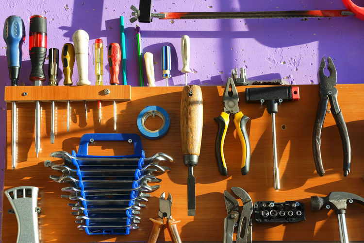Close-up of various tools hanging on wall