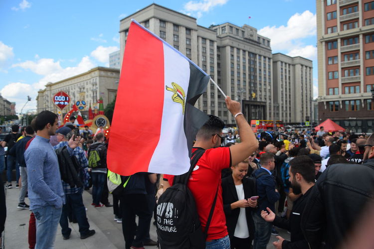 People on street against buildings in city