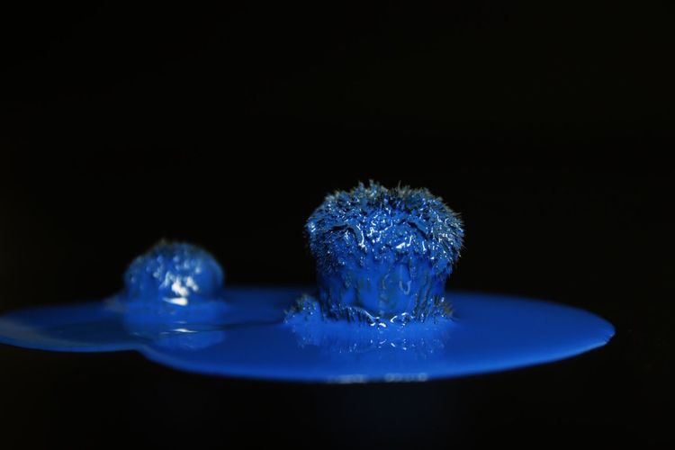 Close-up of water splashing on table against black background