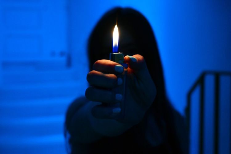 Close-up of woman holding cigarette light 