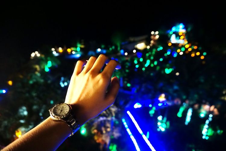Close-up of hand holding illuminated multi colored lights