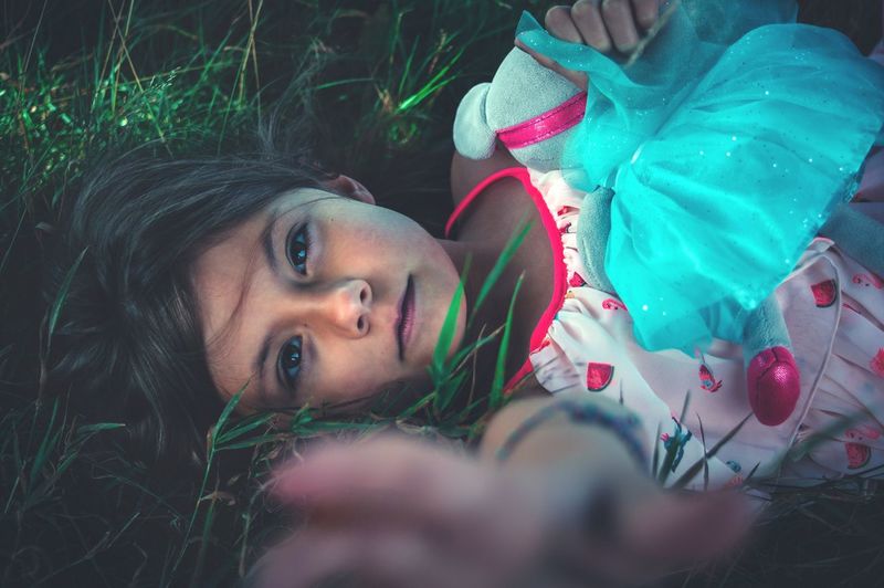 High angle portrait of smiling girl lying on grass