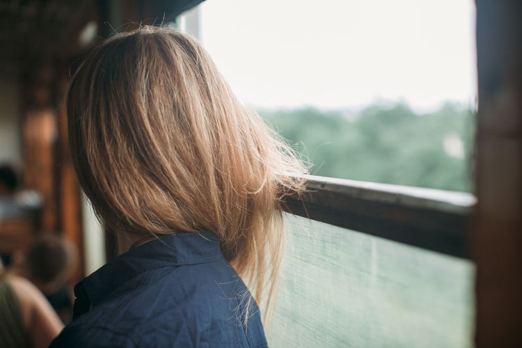 Side view of woman by window in train