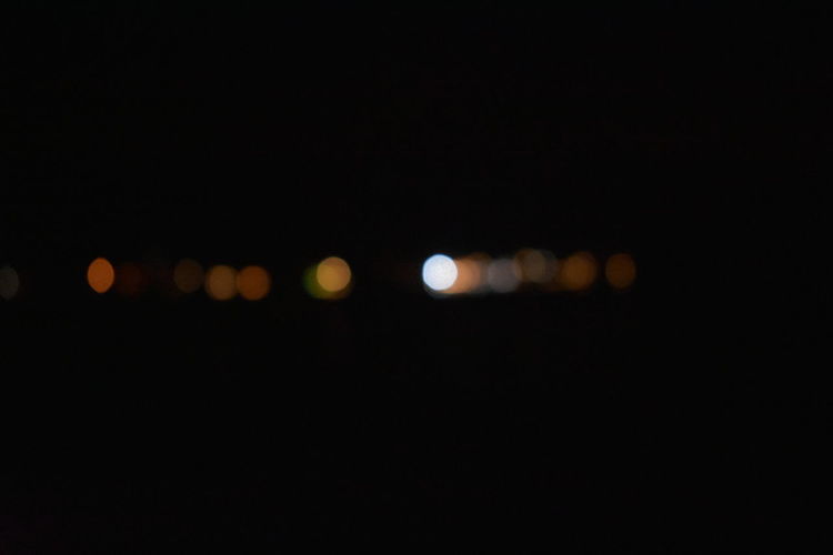 Defocused lights against sky at night