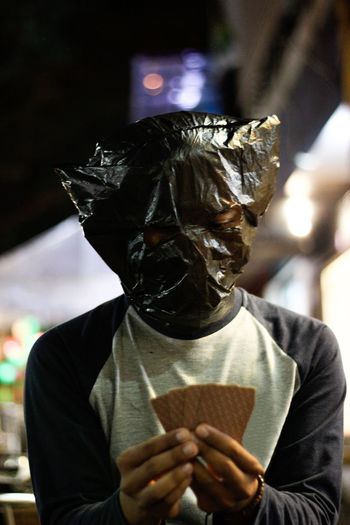 Close-up of man wearing plastic bag on head