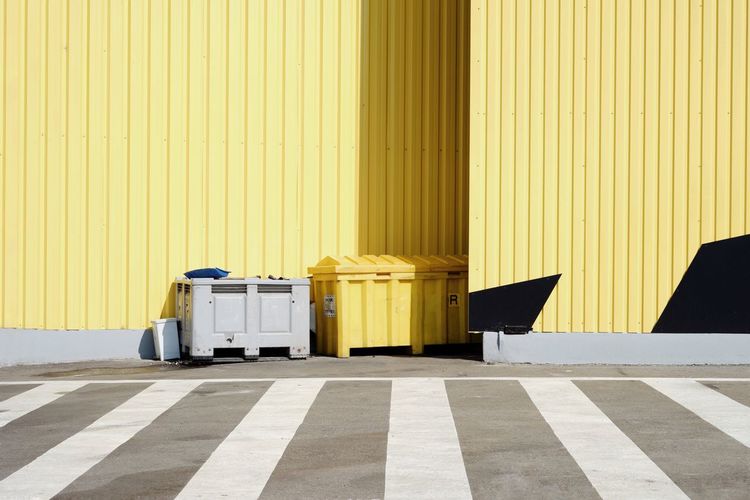 Garbage bins against wall on street