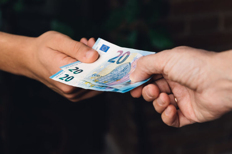 Cropped image of hands holding paper currency