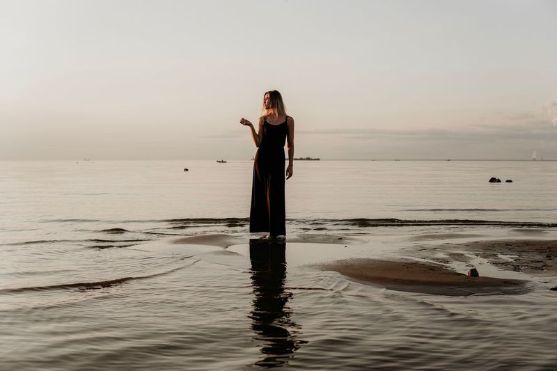 Full length of woman standing at beach