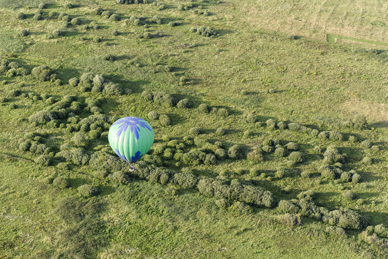 Aerial view of hot air balloon over green landscape