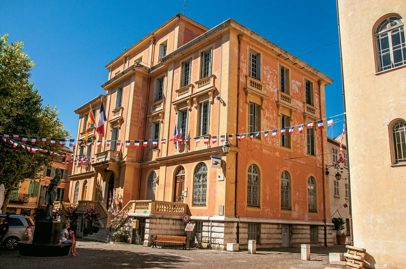 View of the city hall building and flags in vence, in the french provence.