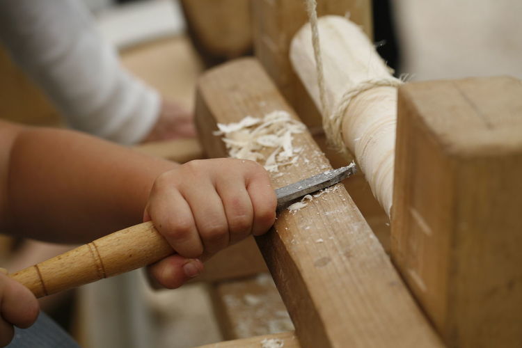 Cropped hands of child working in carpentry