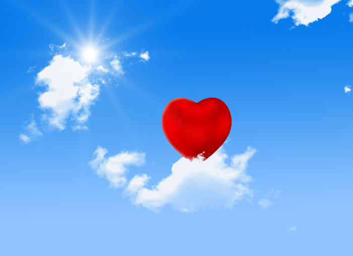 Low angle view of heart balloons against sky