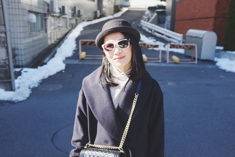 Portrait of woman wearing sunglasses while standing in city