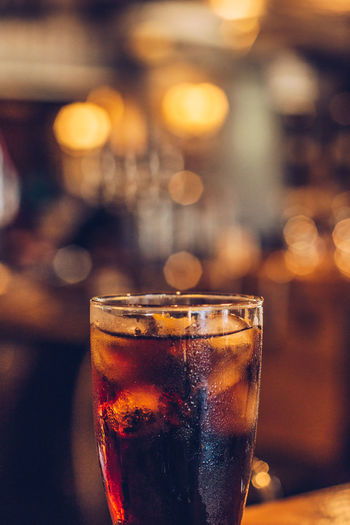 Close-up of cold coke glass at a bar counter
