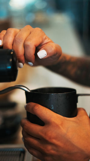 Close-up of woman filling coffee in mug