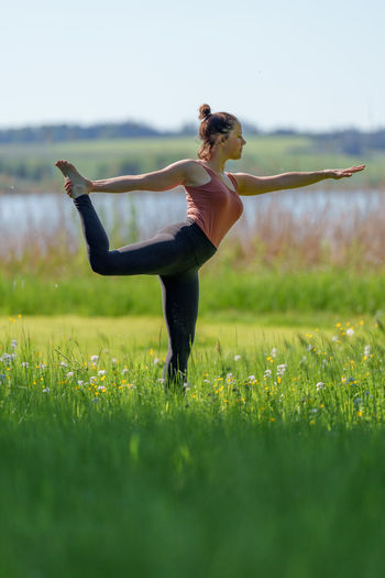 Full length of woman doing yoga on field