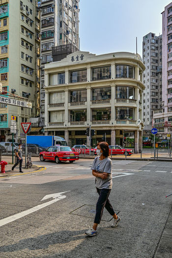 Side view of woman walking on street in city