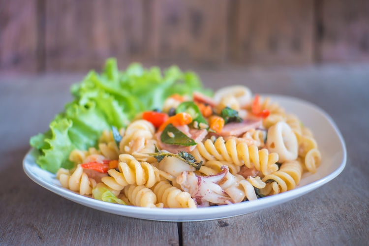 Close-up of pasta served in plate on wooden table
