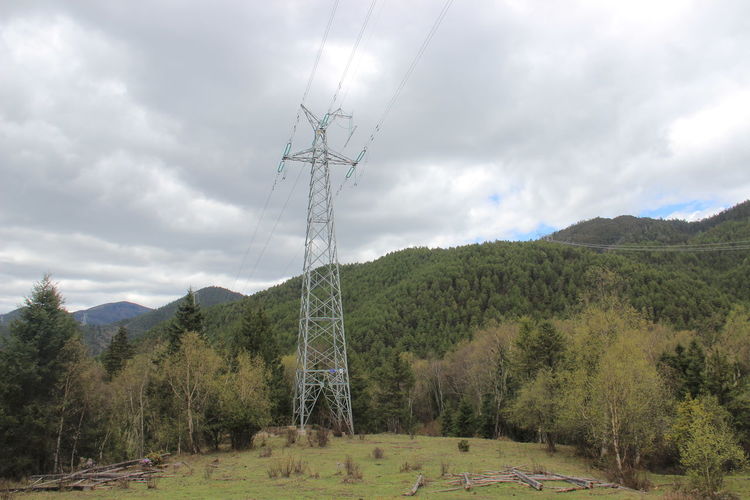 Electricity pylon on land against sky