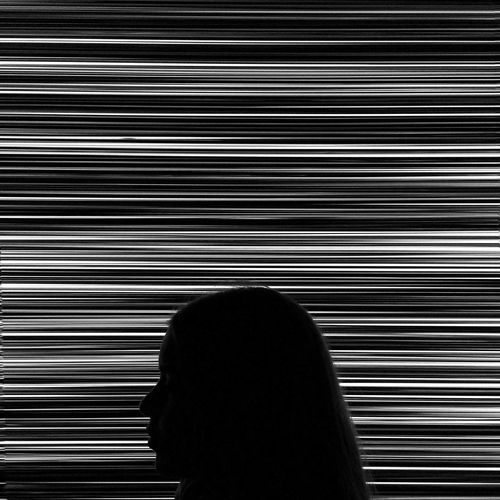 Close-up of silhouette woman against patterned wall