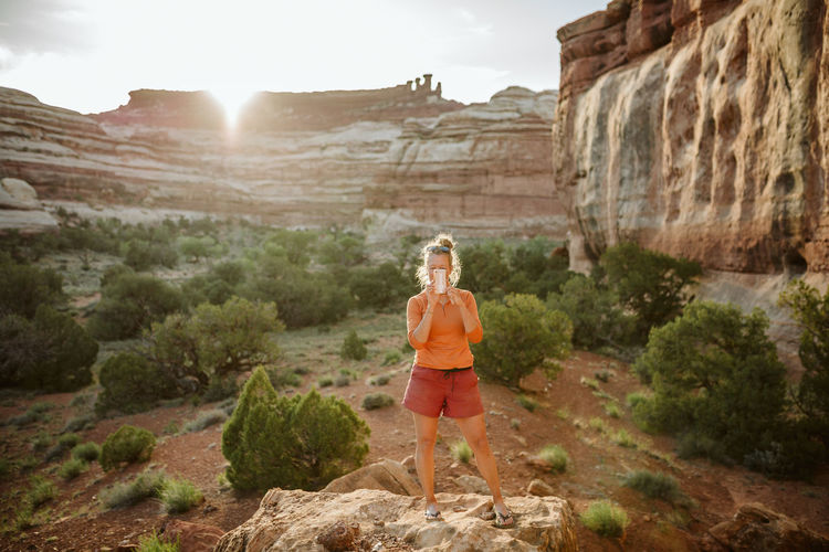 Woman takes picture with cell phone in a desert oasis of utah