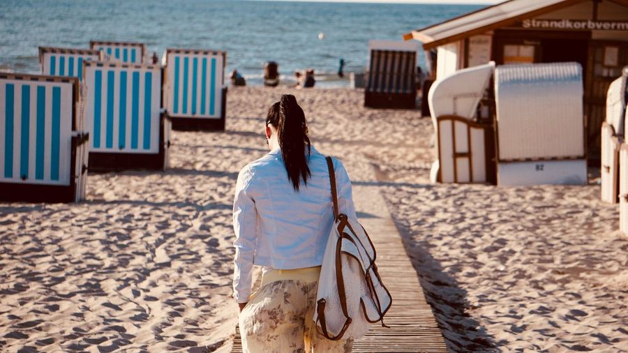 Rear view of woman walking at beach