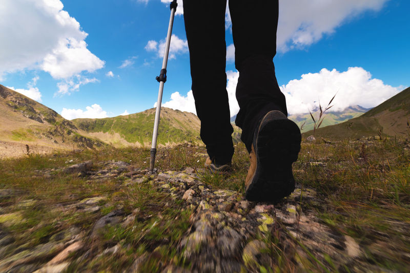 Legs of an adult in boots for walking in the mountains. travel and hiking concept. ground view from