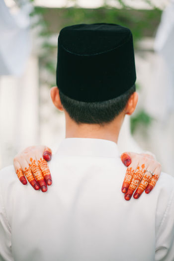 Rear view of man with woman hands on shoulders