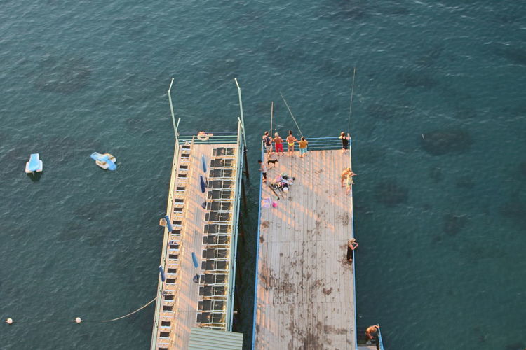 High angle view of people standing on jetty over sea